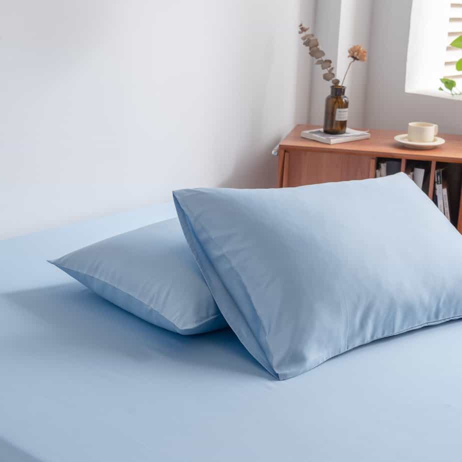 Licht blauwe bamboe kussenslopen op een bed